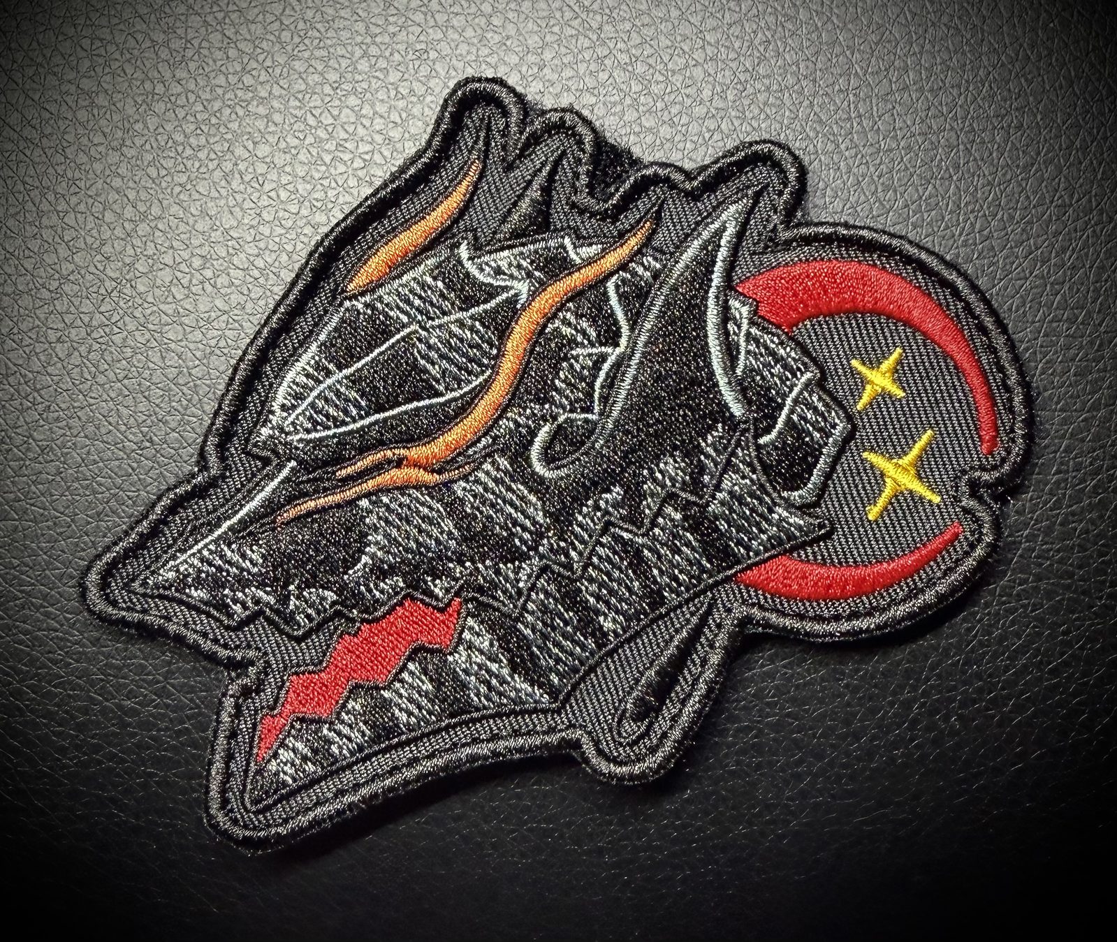 Black wolf head morale patch with red crescent moon and gold stars