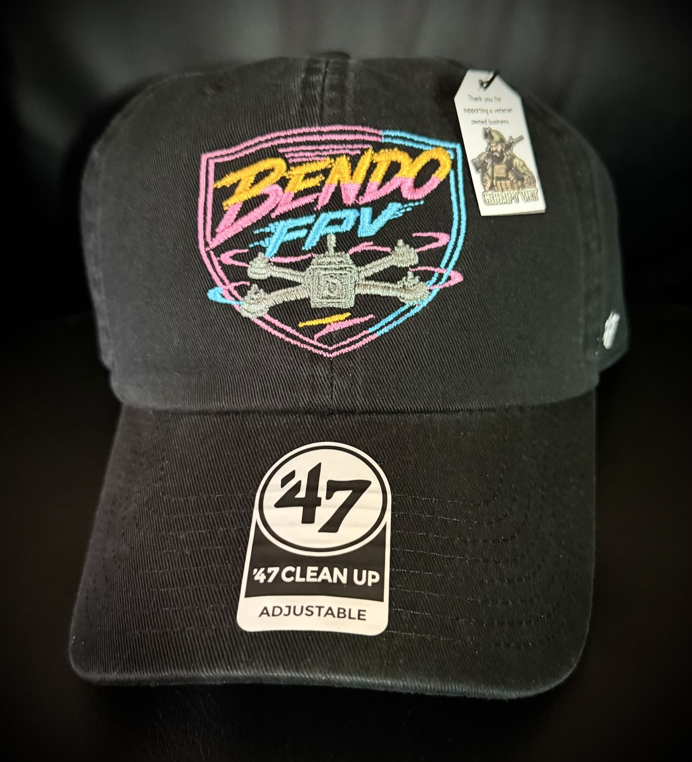 Custom embroidered black hat with neon FPV drone design