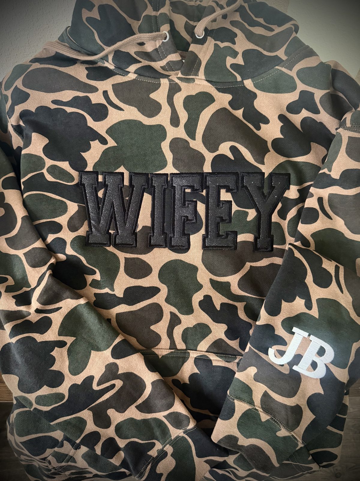 Camo hoodie with black puff embroidered WIFEY lettering and sleeve monogram