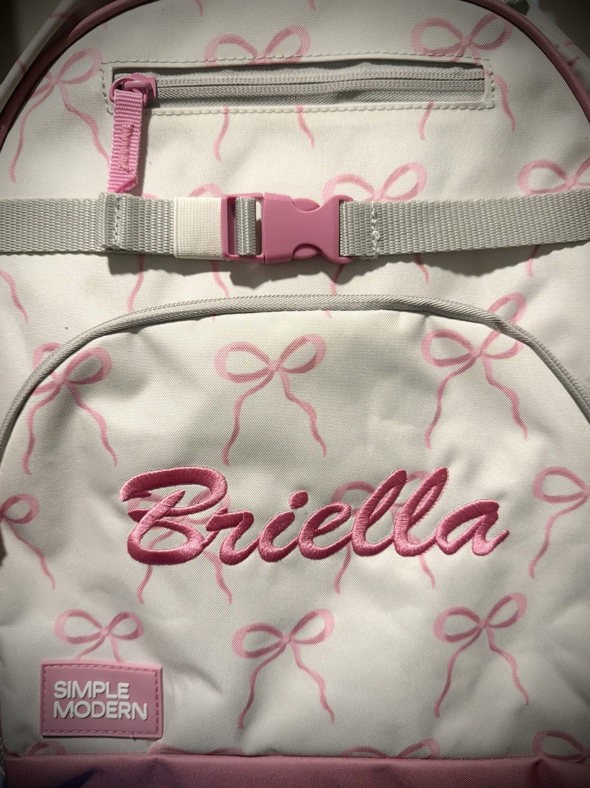 Pink bow backpack with custom Briella script embroidery